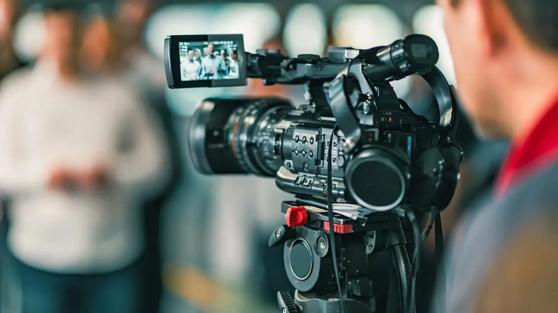 A technician managing a professional video camera during an event