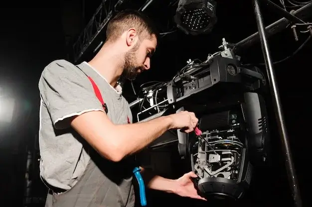 An AV technician adjusting lighting on a stage