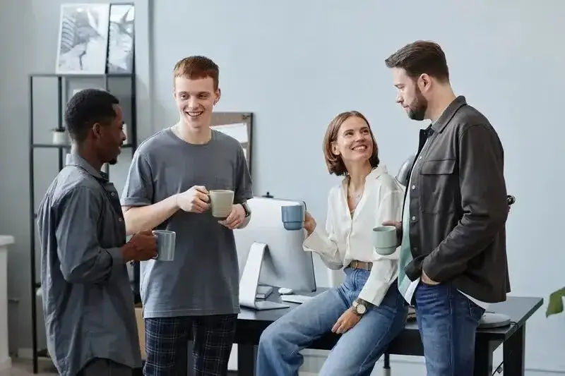 Attendees networking during a coffee break in a bright, modern lounge